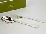 two forks and a spoon sitting next to a green box