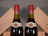 two bottles of red wine sitting next to each other on a table