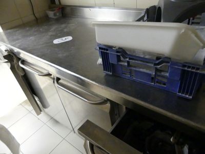 plan de travail en acier inoxydable dans une cuisine professionnelle, avec des bacs bleus