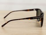 sunglasses on a wooden table with a white wall in the background
