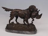 statue of a dog with a duck in its mouth on a marble base