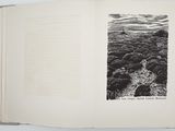 an open book with a black and white photo of rocks and water