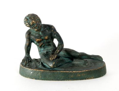 statue of a man sitting on a base with his foot on the ground