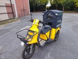 une moto jaune avec un coffre noir à l'arrière