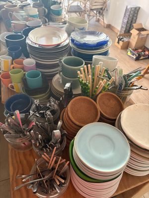 de nombreuses assiettes et bols posés sur une table, avec des couverts et des cuillères