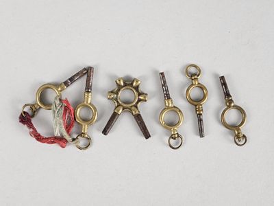 plusieurs types différents de crochets et de chaînes métalliques sur une surface blanche