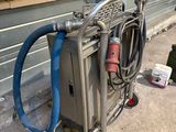 a cart with a hose attached to it next to a building