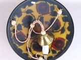 a black and yellow plate with a gold bell on it