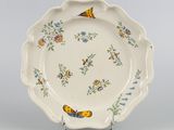 une assiette blanche décorée de fleurs bleues et jaunes