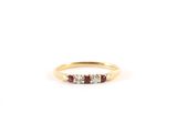 une bague en or sertie de trois pierres et d'un petit diamant
