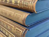 several old books stacked on top of each other on a table