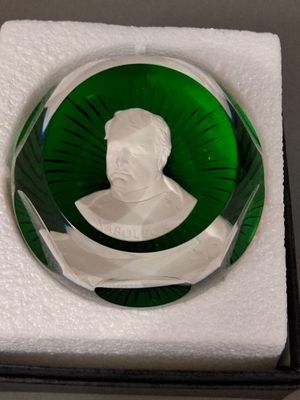 une assiette en verre vert sur laquelle est représenté le buste d'un homme