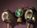 three old gas masks on display on a purple surface