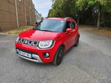 La jeep rouge est garée sur le bord de la route.