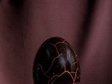 a black marble ball sitting on top of a purple cloth