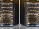 two bottles of wine sitting on top of a table next to each other