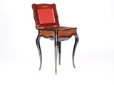 une petite table sur laquelle est posée une chaise rouge