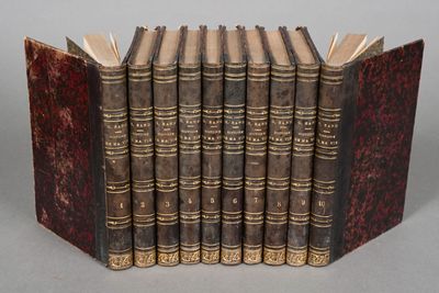 six old books are lined up in a row on a table