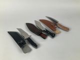 four different types of knives are lined up on a white surface