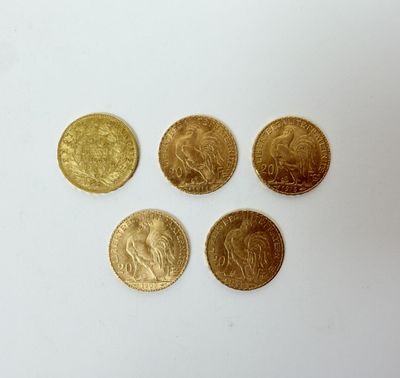 quatre pièces d'or posées sur une surface blanche
