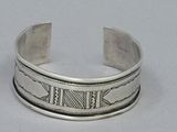 silver cuff bracelet with roman numerals on the sides of it