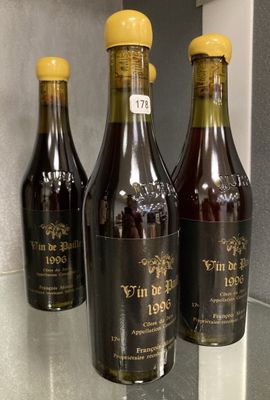 three bottles of wine sitting on a counter in a kitchen