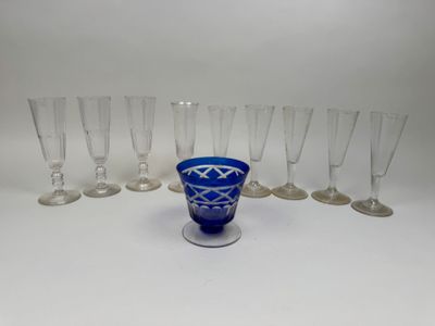 six blue glass goblets and six empty wine glasses on a white surface