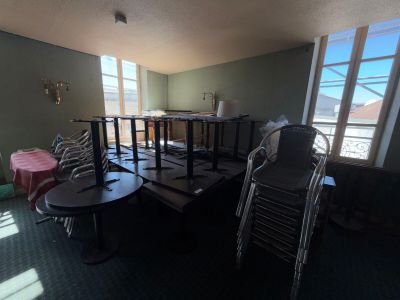 tables and chairs in a room with a view of a balcony