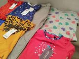 a lot of t - shirts that are on the table