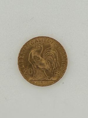 a gold coin with a rooster on it on a white surface