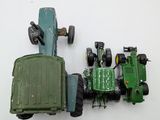 a green toy tractor and a green toy tractor on a white surface
