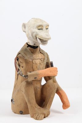 une statue représentant un singe tenant une carotte dans la main