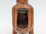 wooden sculpture of a woman sitting in a chair with her back to the camera