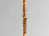 a close up of a wooden clarinet on a gray background