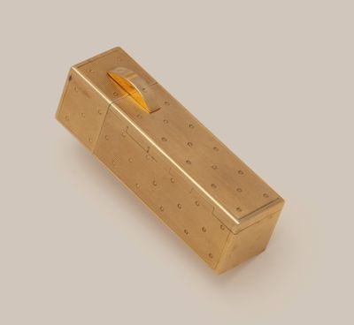 a gold box with a pencil sticking out of it