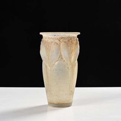 un vase blanc posé sur une table sur fond noir