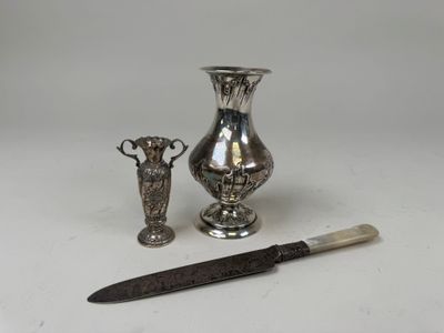 two silver vases and a knife sitting next to each other