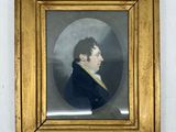 un portrait ancien représentant un homme vêtu d'un manteau noir, dans un cadre doré