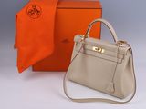 the hermes bag is sitting next to an orange box