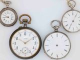several different types of pocket watches are displayed on a white surface