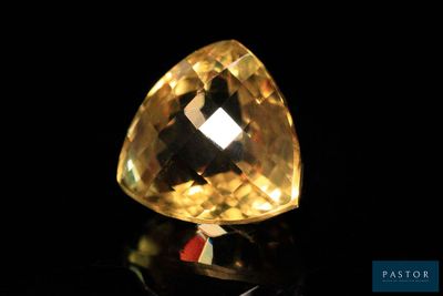 a close up of a yellow diamond on a black surface