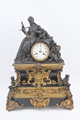 une horloge noire et dorée surmontée d'une statue
