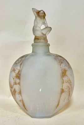a small glass bottle with a figurine sitting on top of it