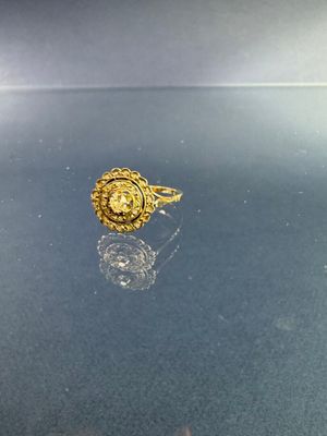 bague plaquée or ornée d'un visage de lion sur une surface brillante