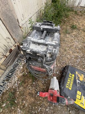 two tools that are sitting on the ground next to a building