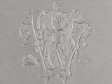 an antique silver plate with a monogram on it