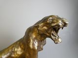 a bronze statue of a lion with its mouth open