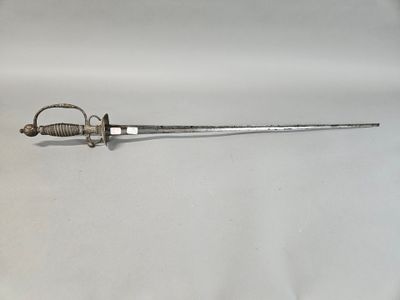 an old sword is laying on a white surface