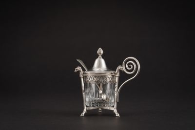 une théière ancienne en argent avec une anse, sur fond noir