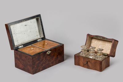 deux petites boîtes en bois contenant de l'argenterie, posées sur une surface grise